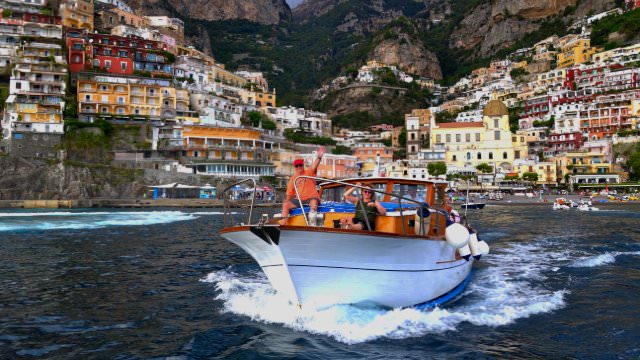 Our private boats take us for a sunset prosecco toast off the coast of Positano